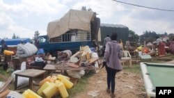 Une femme marche entre les biens des personnes qui sont expulsées dans le bidonville de Kangondo à Kigali au Rwanda, le 16 septembre 2022. (Photo AFP)