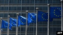 FILE - Flags fly outside the European Commission building in Brussels, June 16, 2022.
