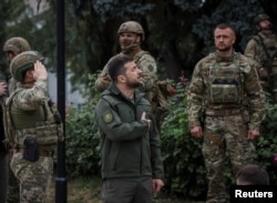 ولودیمیر زلنسکی، رئیس جمهوری اوکراین، به هنگام بازدید از شهر آزاد شده ایزیوم در منطقه خارکیف در شمال شرق اوکراین. ۱۴ سپتامبر ٢٠٢٢