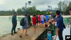 ជនជាតិ​ចិន​ដើរ​លើ​ស្ពាន​នៅ​កោះ​មួយ​ក្នុង​ខេត្ត​ព្រះសីហនុ បន្ទាប់​ពី​ពួកគេ​ត្រូវ​បាន​ជួយស​ង្គ្រោះ​ពី​ហេតុការណ៍​លិច​ទូក កាល​ពី​ថ្ងៃ​ព្រហស្បតិ៍ ទី ២២ ខែកញ្ញា ឆ្នាំ២០២២។ (Preah Sihanouk province Authority Police via AP)