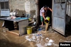 A woman clears her home from mud following the flood caused by Super Typhoon Noru, in Marikina City, Metro Manila, Philippines, Sept. 26, 2022. (REUTERS/Lisa Marie David)