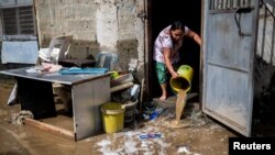 Seorang perempuan membersihkan rumahnya dari lumpur setelah diterjang banjir yang dipicu oleh Topan Super Noru, di Marikina City, Metro Manila, Filipina, 26 September 2022. (REUTERS/Lisa Marie David)