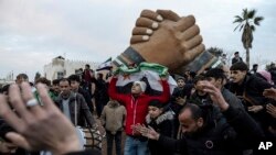 Orang-orang berkumpul untuk merayakan jatuhnya pemerintah Suriah di Manbij, Suriah, Minggu, 8 Desember 2024. (Ugur Yildirim/Dia Photo via AP)