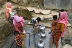 FILE - Rohingya refugees collect drinking water at the Shalbagan refugee camp in Teknaf, Bangladesh, March 5, 2019.