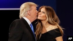 Kandidat presiden AS dari Partai Republik Donald Trump mencium istrinya Melania setelah debat kepresidenan di Hofstra University di Hempstead, New York (26/9). (AP/David Goldman)