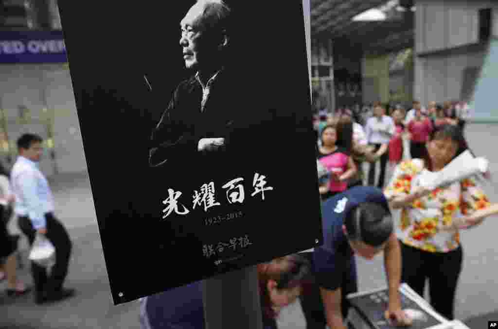 Pegawai kantoran di distrik keuangan Singapura membeli koran lokal edisi khusus mengenai kehidupan mendiang Lee Kuan Yew (23/3).&nbsp;​(AP/Wong Maye-E)