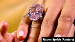 Seorang model menampilkan berlian merah muda 'Bintang Merah Muda' 59,60 karat berbentuk oval di Sotheby's di Jenewa 25 September 2013. (Foto: REUTERS/Ruben Sprich)
