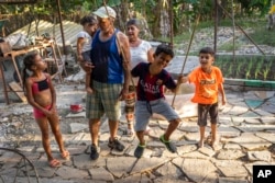 FILE - Gustavo Pijuan and his wife, Sura Victorero, are pictured with their grandchildren at their home in Minas, Cuba, April 29, 2022. Cuba's new Families Code contains an extension of rights of grandparents.(AP Photo/Ramon Espinosa)