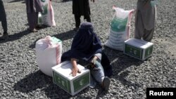 یک زن افغانستانی منتظر دریافت بسته غذایی از طرف یک گروه بشردوستانه عربستان سعودی در کابل است (آرشیو)
