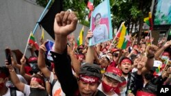 Myanmar nationals living in Thailand with a picture of deposed Myanmar leader Aung San Suu Kyi, seen at center, stage a rally outside Myanmar's embassy in Bangkok, Thailand, July 26, 2022.