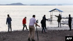 FILE - Journalists visit the shrinking salt lake of Urmia, whose receding shoreline is considered one of the worst ecological disasters of the past 25 years, in northwestern Iran, Dec. 8, 2018.