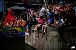 Hundreds of thousands of people lined canals in the Dutch capital to watch the Canal Parade, in Amsterdam, Netherlands, Aug. 6, 2022.