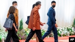 Chinese Foreign Minister Wang Yi, center, departs an ASEAN Gala Dinner within minutes of arriving at the Chroy Changvar International Convention and Exhibition Center in Phnom Penh, Aug. 4, 2022.