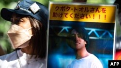 (FILES) Seorang aktivis memegang plakat bergambar Toru Kubota, warga negara Jepang yang ditahan di Myanmar, dalam aksi unjuk rasa di depan Kementerian Luar Negeri di Tokyo, 31 Juli 2022 . (Philip FONG / AFP)