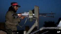 FILE: A Taliban fighter stands guard at the site of an explosion in front of the Kabul International Cricket Stadium, in Kabul, Afghanistan, July 29, 2022