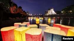 People release paper lanterns on the Motoyasu River facing the gutted Atomic Bomb Dome in remembrance of atomic bomb victims on the 77th anniversary of the bombing, in Hiroshima, Japan, Aug. 6, 2022. (Kyodo via Reuters)