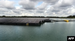 Panel surya terapung dari taman surya Uivermeertjes, yang dioperasikan oleh BayWa r.e., di Deest, dekat Arnhem, pada 11 Juli 2022. (François WALSCHAERTS / AFP)