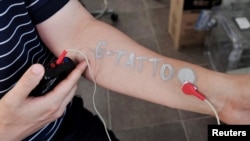 Steve Park, Materials Science & Engineering professor at Korea Advanced Institute of Science and Technology (KAIST), demonstrates an electronic tattoo on his arm connected with an electrocardiogram monitoring system in Daejeon, South Korea, July 26, 2022. (REUTERS/Minwoo Park)