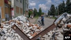 A local resident holds his bicycle in Bakhmut, eastern Ukraine, on Aug. 4, 2022, amid the Russian invasion of Ukraine. 