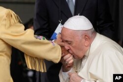 Paus Fransiskus mencium tangan seorang perempuan warga Pribumi (suku asli) Kanada saat ia tiba di bandara Internasional Edmonton, Kanada, Minggu, 24 Juli 2022.