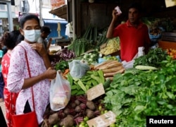 FILE - A vendor sells vegetables to a customer amid the rampant food inflation, amid Sri Lanka's economic crisis, in Colombo, Sri Lanka, July 29 , 2022.