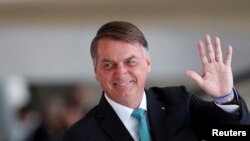 Presiden Brazil Jair Bolsonaro menyapa awak media setelah melakukan pertemuan dengan Presiden Hungaria Katalin Novak di Istana Planalto di Brasilia, Brazil, pada 11 Juli 2022. (Foto: Reuters/Adriano Machado)