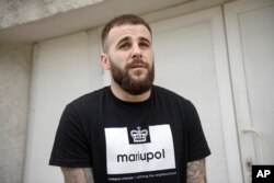 An officer of the Azov regiment, with the nom de guerre David, stands near a city crematorium to pay the last tribute to a serviceman killed in a battle against Russian troops in Kyiv, Ukraine, July 21, 2022.