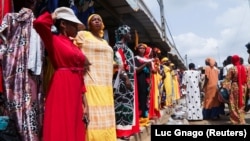 Des femmes devant un magasin de vêtements dans une rue du quartier populaire d'Adjame à Abidjan, en Côte d'Ivoire, le 1er mars 2022. 