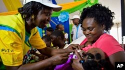 FILE - A health worker vaccinates a child against malaria in Homabay County, western Kenya.