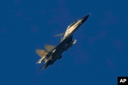 FILE - A Chinese J-11 military fighter jet flies above the Taiwan Strait near Pingtan, the closest land of mainland China to the island of Taiwan, in Pingtan in southeastern China's Fujian Province, Aug. 5, 2022. (AP Photo/Ng Han Guan)