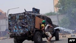 FILE - Sudanese anti-coup protesters clash with a riot police vehicle during a demonstration against military rule, in Khartoum, June 30, 2022. 