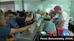 Para sukarelawan Kyiv setiap hari menyediakan 900 porsi makanan bagi warga desa Borodyanka di luar ibu kota Ukraina. (VOA-videograb/Pavel Suhodolskiy) 