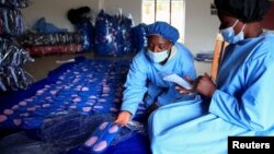 Para petugas tengah bekerja di pabrik pembalut yang dapat digunakan kembali di Bonda Women Craft Centre, di distrik Mutasa, di Mutare, Zimbabwe, 13 Juli 2022. (REUTERS/Philimon Bulawayo)