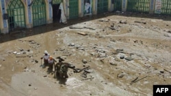This picture, provided by the Iranian Red Crescent (RCS), shows members of a rescue team working at the site of a flash flood in the Emamzadeh Davoud northwestern part of Tehran, on July 28 2022. 