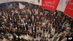 Para pendukung dari Ulama Syiah Irak yang berpengaruh, Muqtada al-Sadr, melakukan salat di dalam gedung parlemen di Baghdad, Irak, di tengah aksi protes menduduki gedung parlemen pada 1 Agustus 2022. (Foto: AP/Anmar Khalil)