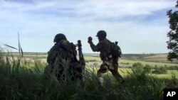 In this handout photo released by Russian Defense Ministry Press Service on July 20, 2022, Russian soldiers fire a mortar from their position at an undisclosed location in Ukraine. 