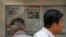 Men are seen at a newspaper display reporting on U.S. House Speaker Nancy Pelosi's Asia visit, at a stand in Beijing, China, July 31, 2022. 