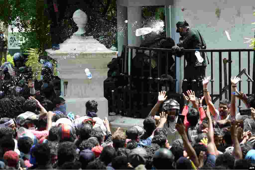 Demonstrators throw bottles of water to army personnel during an anti-government protest outside the office of Sri Lanka's prime minister in Colombo, July 13, 2022. 
