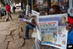 Seorang pria membaca koran yang halaman depannya menampilkan dua calon presiden terkemuka Raila Odinga dan William Ruto, di sebuah jalan di pusat kota Nairobi, Kenya, Sabtu, 6 Agustus 2022. (AP)