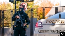 FILE - A US Secret Service officer stands guard as President Donald Trump's motorcade arrives at the White House after golfing at his Trump National Golf Club in Sterling, Virginia, Nov. 8, 2020, a day after he was defeated by President-elect Joe Biden.