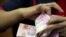 FILE: Seorang karyawan menghitung uang kertas rupiah Indonesia di kantor penukaran mata uang di Jakarta, 23 Oktober 2018. (REUTERS/Beawiharta)