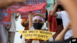 Protesters mark the 6th anniversary of the 2016 decision under the U.N. Convention of the Law of the Sea against China's aggressive actions in the disputed sea during a rally outside the Chinese consulate in Makati, Philippines, Tuesday, July 12, 2022. (AP Photo/Aaron Favila)