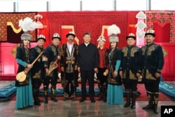 Dalam foto yang dirilis oleh Kantor Berita Xinhua China, Presiden China Xi Jinping, (tengah), berpose bersama para pemain Manas, sebuah epik budaya warga Kirgistan, di Museum Daerah Otonomi Uyghur Xinjiang, Urumqi, barat laut China, Daerah Otonomi Uyghur, Rabu, 13 Juli 2022. (Xie Huanchi/Xinhua via AP)