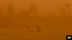 FILE - Fishermen navigate on the Shatt al-Arab waterway during a sandstorm in Basra, Iraq, May 23, 2022. This year's annual U.N. climate change conference, known as COP27, is being held in Egypt in November, throwing a spotlight on the region. (AP Photo/Nabil al-Jurani)