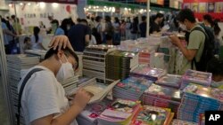 Visitors read at a booth during the annual book fair in Hong Kong, July 20, 2022. 