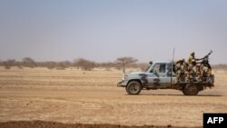  Des soldats burkinabè patrouillent à bord d'un pick-up sur la route de Dori au camp de réfugiés de Goudebo, le 3 février 2020. 