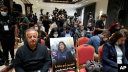 A photo of slain Palestinian-American journalist Shireen Abu Akleh is placed on a chair as journalists wait for remarks by President Biden and Palestinian President Mahmoud Abbas following their meeting at the West Bank town of Bethlehem, July 15, 2022.