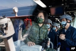 Dalam foto yang dirilis oleh Kantor Kepresidenan Taiwan, Presiden Taiwan Tsai Ing-wen terlihat melalui kaca di atas kapal angkatan laut saat melakukan inspeksi latihan militer tahunan Han Kuang di Taiwan, Selasa, 26 Juli 2022. (Shioro Lee/Kantor Kepresidenan Taiwan via AP)
