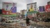 FILE - A man scavenges through rubbish below campaign posters for local government candidates in the Mathare low-income neighborhood of Nairobi, Kenya, Aug. 1, 2022. 