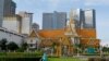 Seorang pria berolahraga di depan gedung Institut Buddhis, yang terletak di sebelah bangunan komersial modern, di Phnom Penh pada 29 Juni 2020. (Foto: AFP/TANG CHHIN Sothy)